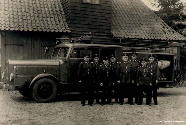Gruppenbild vor Feuerwehrfahrzeug (schwarz-weiß)